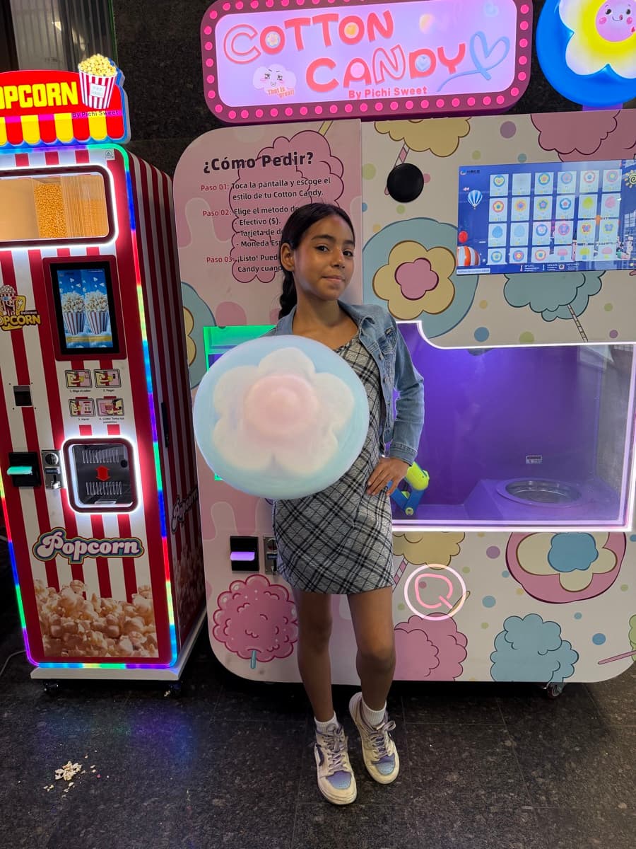 Niña sonriendo con su algodón de azúcar